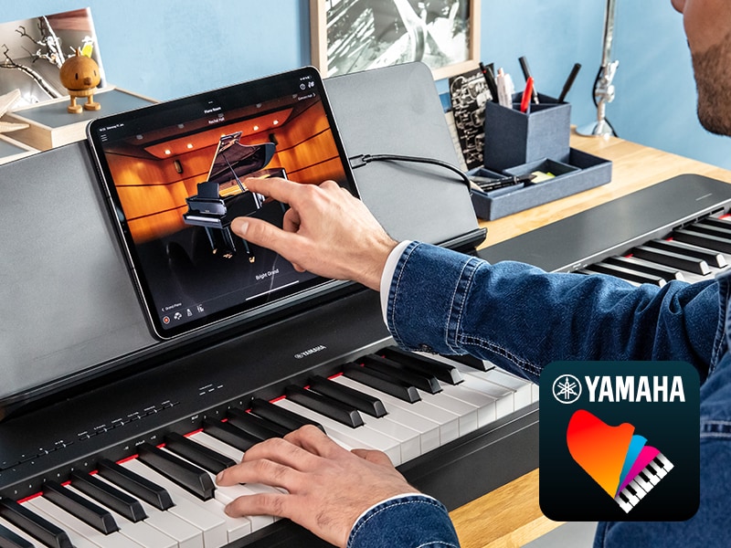 The Yamaha ?Smart Pianist? app icon, together with a tablet placed on the m ature imageusic stand of the P-225
